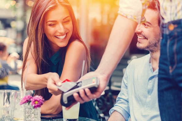 A person is paying for drinks at a cafe with a credit card. 