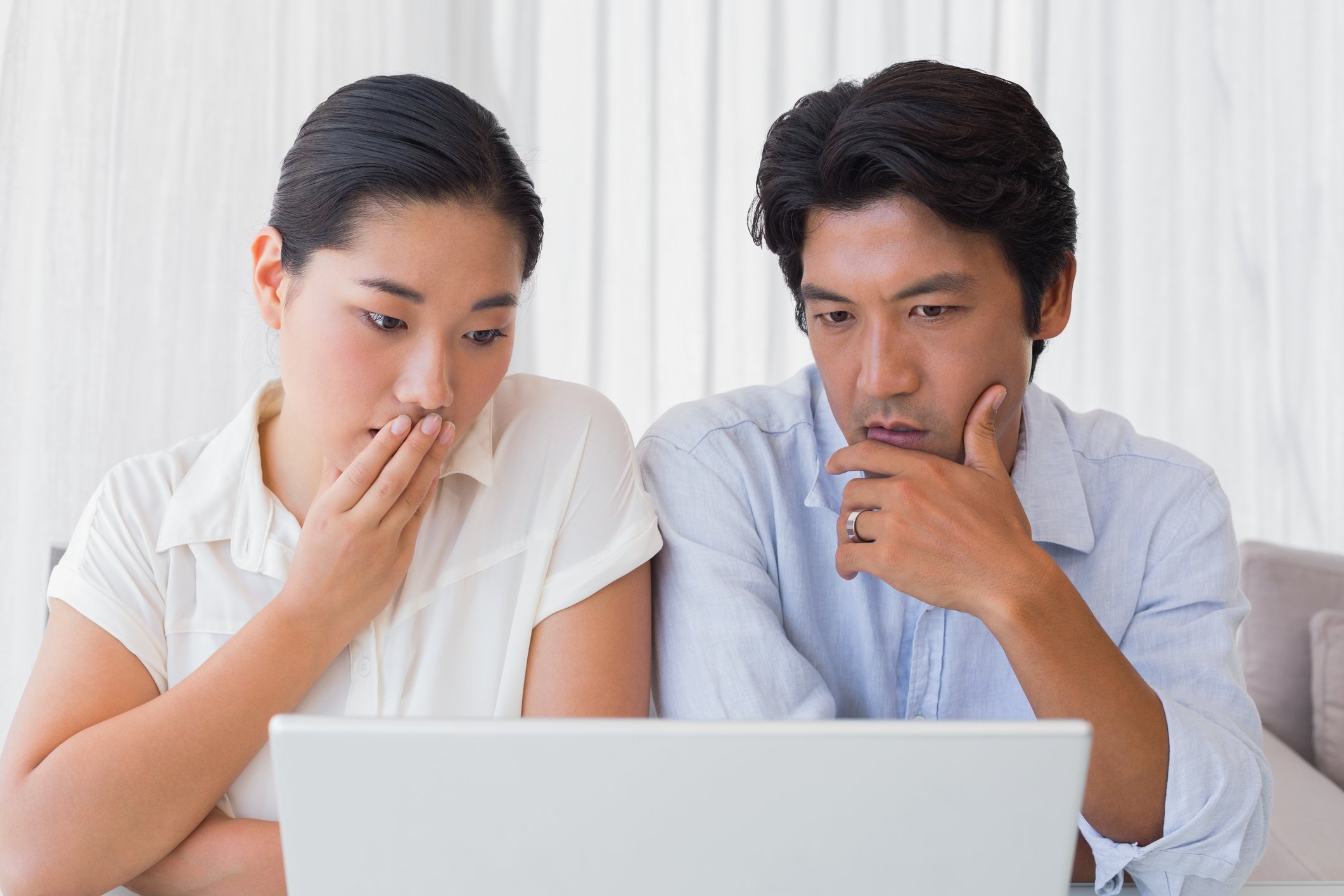Worried Asian couple, laptop