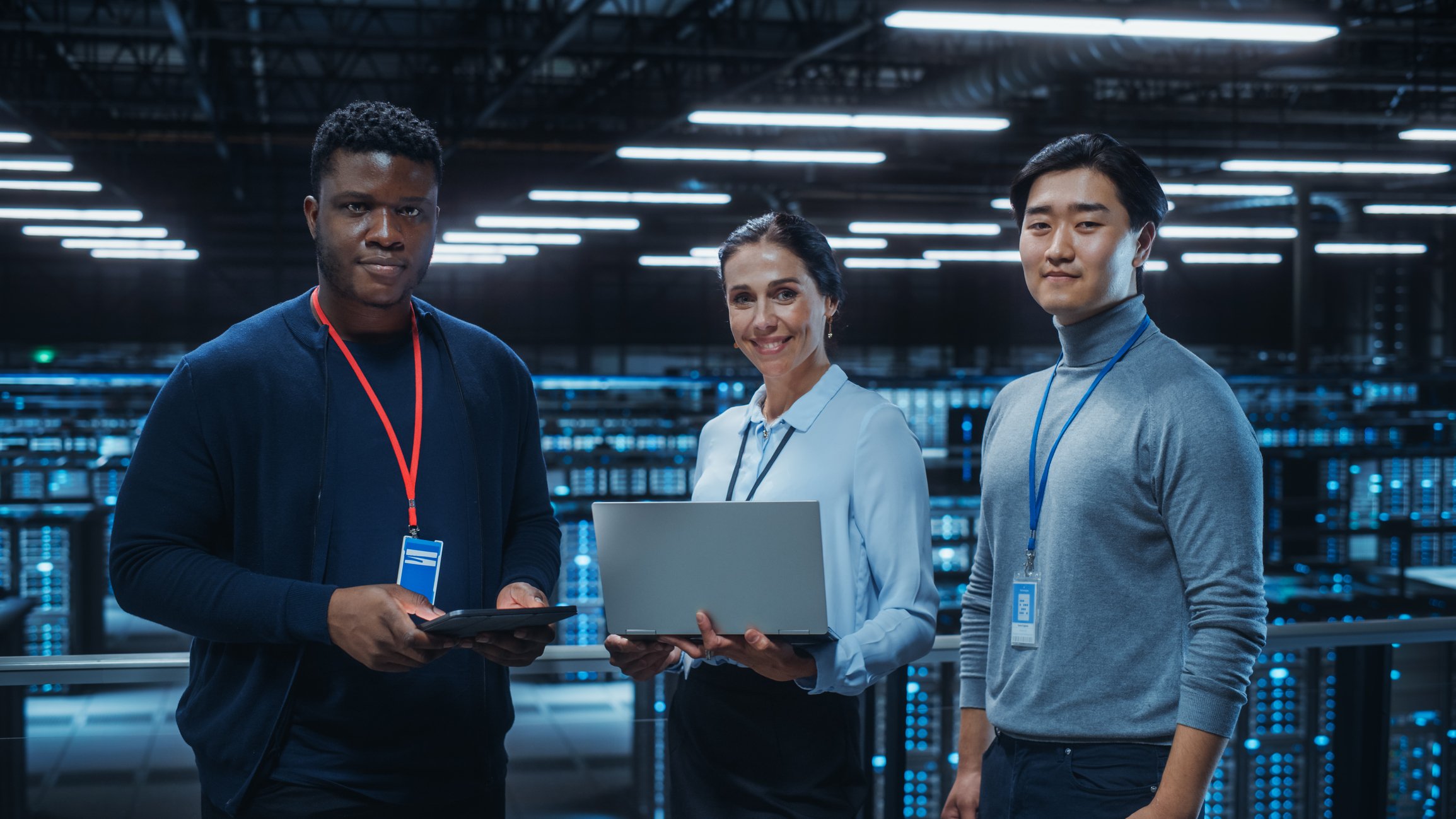 Three young professionals standing together in a data storage facility. 