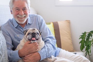 Smiling person holding dog_GettyImages-1326614891