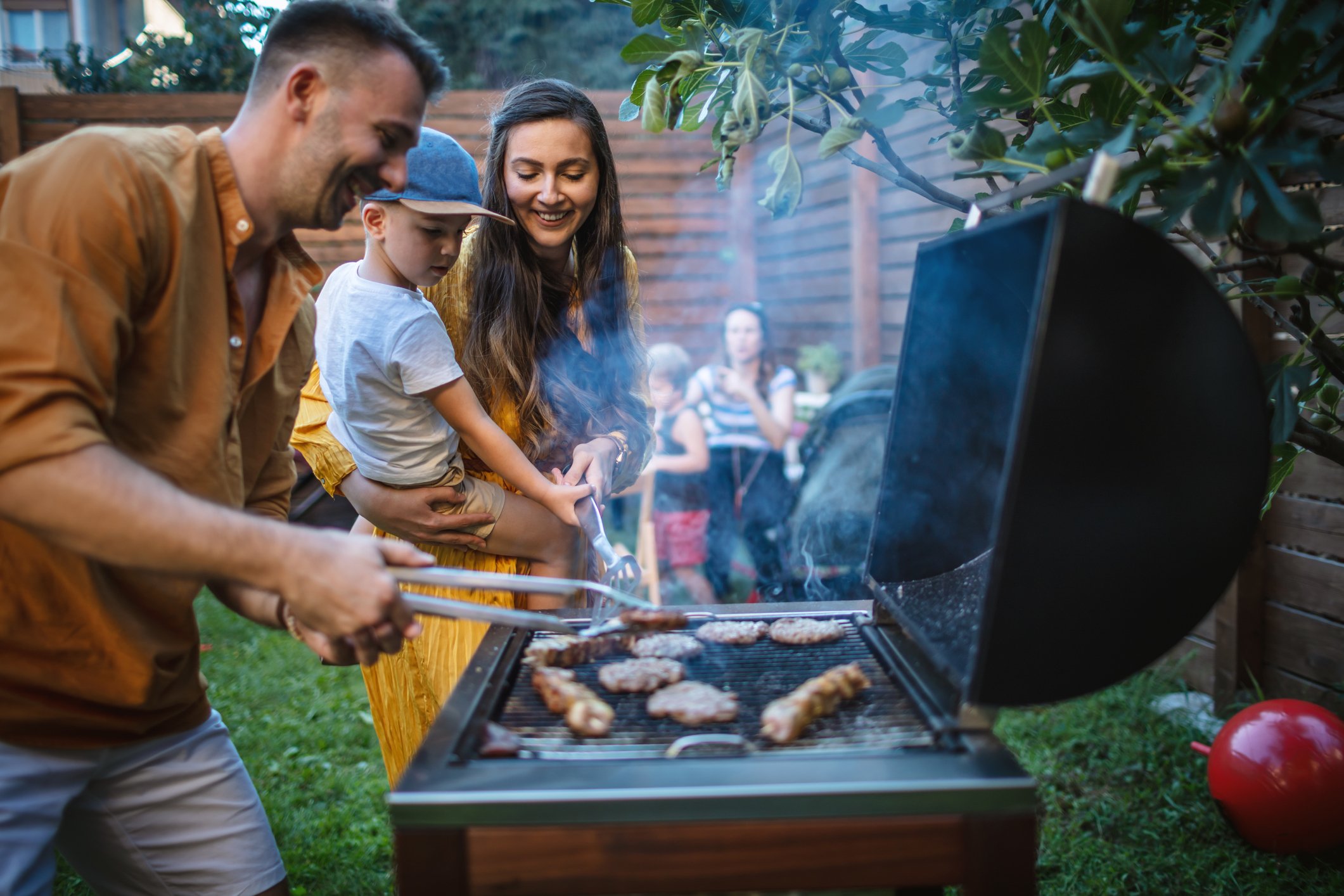 Family barbecuing in the back yard.