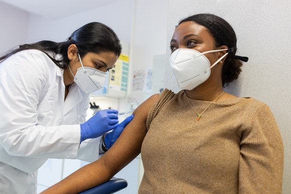 A healthcare professional giving a vaccine shot to a person.