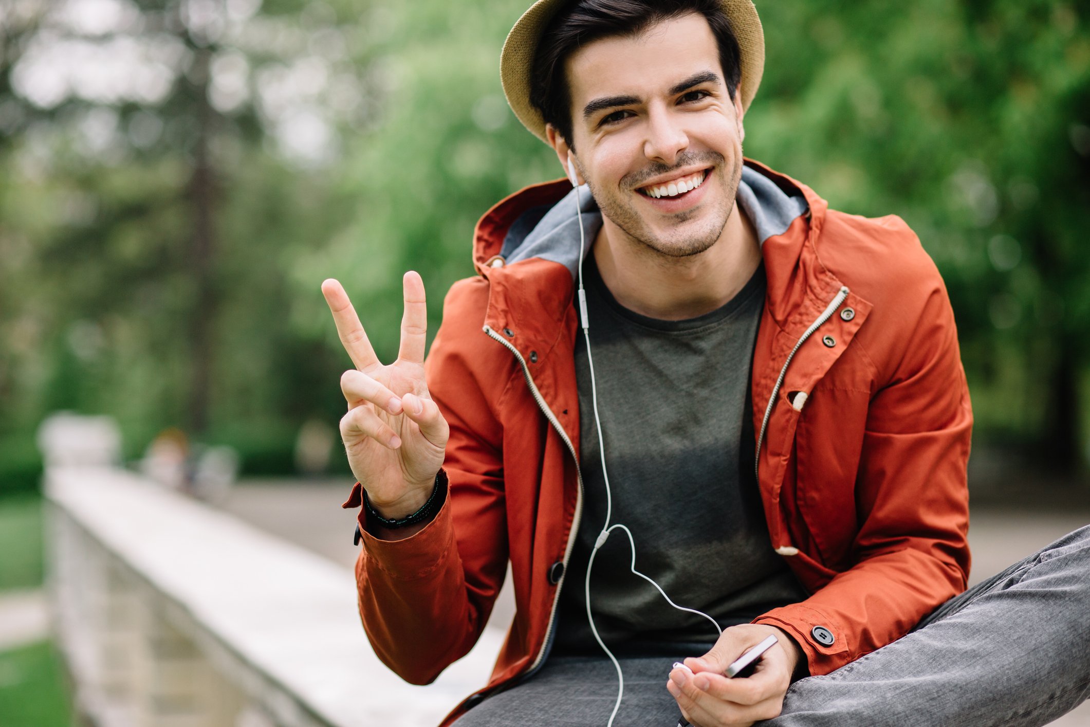 Person showing a peace sign and smiling.