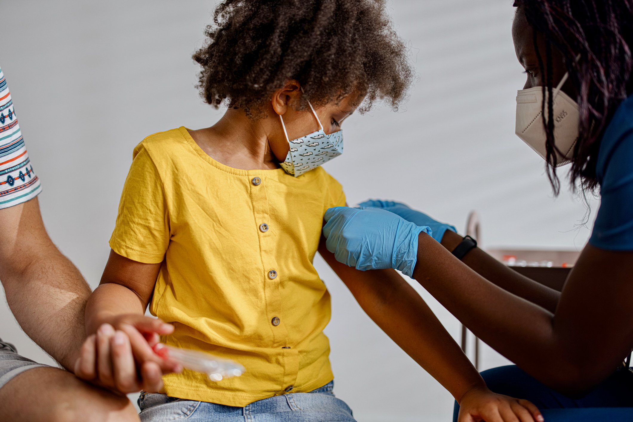 A healthcare professional touching the arm of a child.