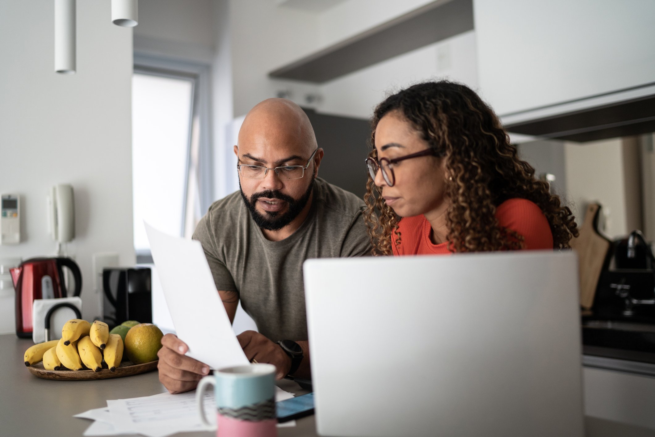Two people at kitchen island discussing financial plan.