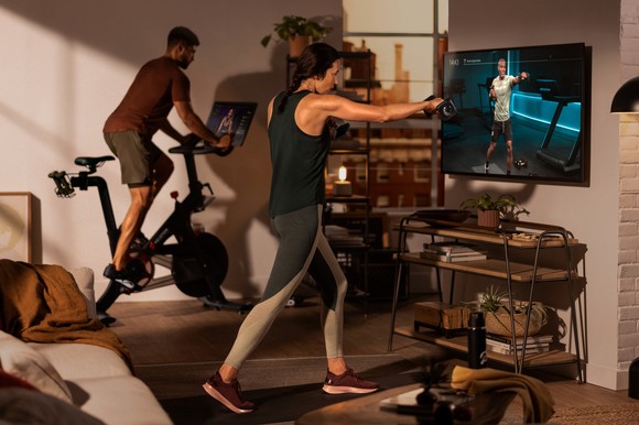 two people working out at home using Peloton equipment
