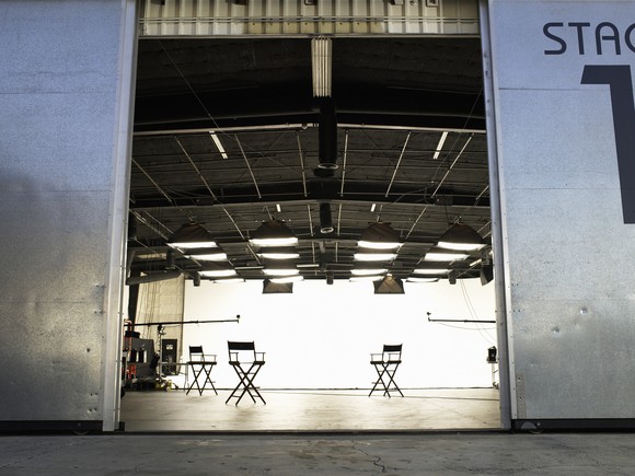 A door opens on an empty sound stage on a studio lot.