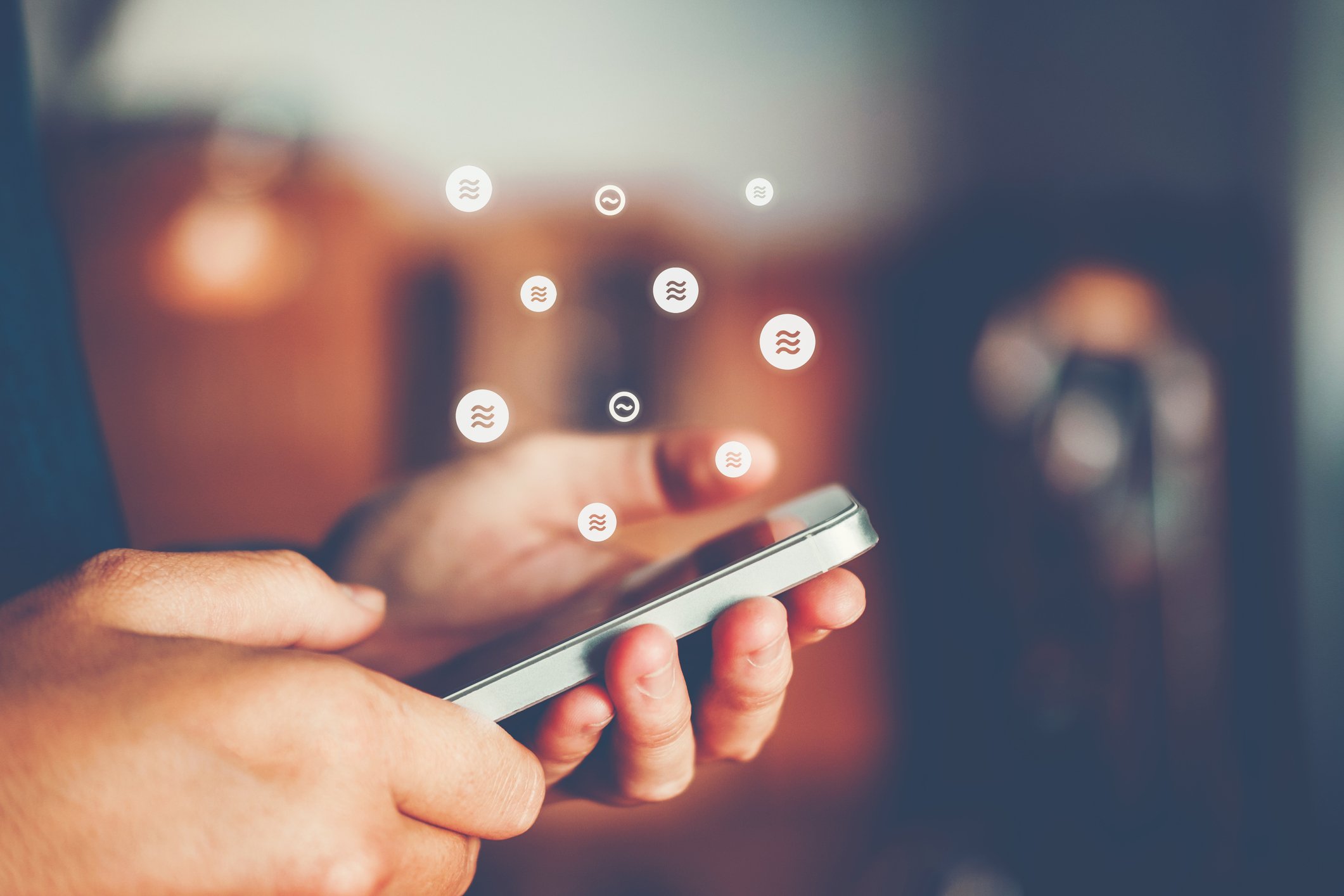 Person holding phone, with various currency symbols emanating out.