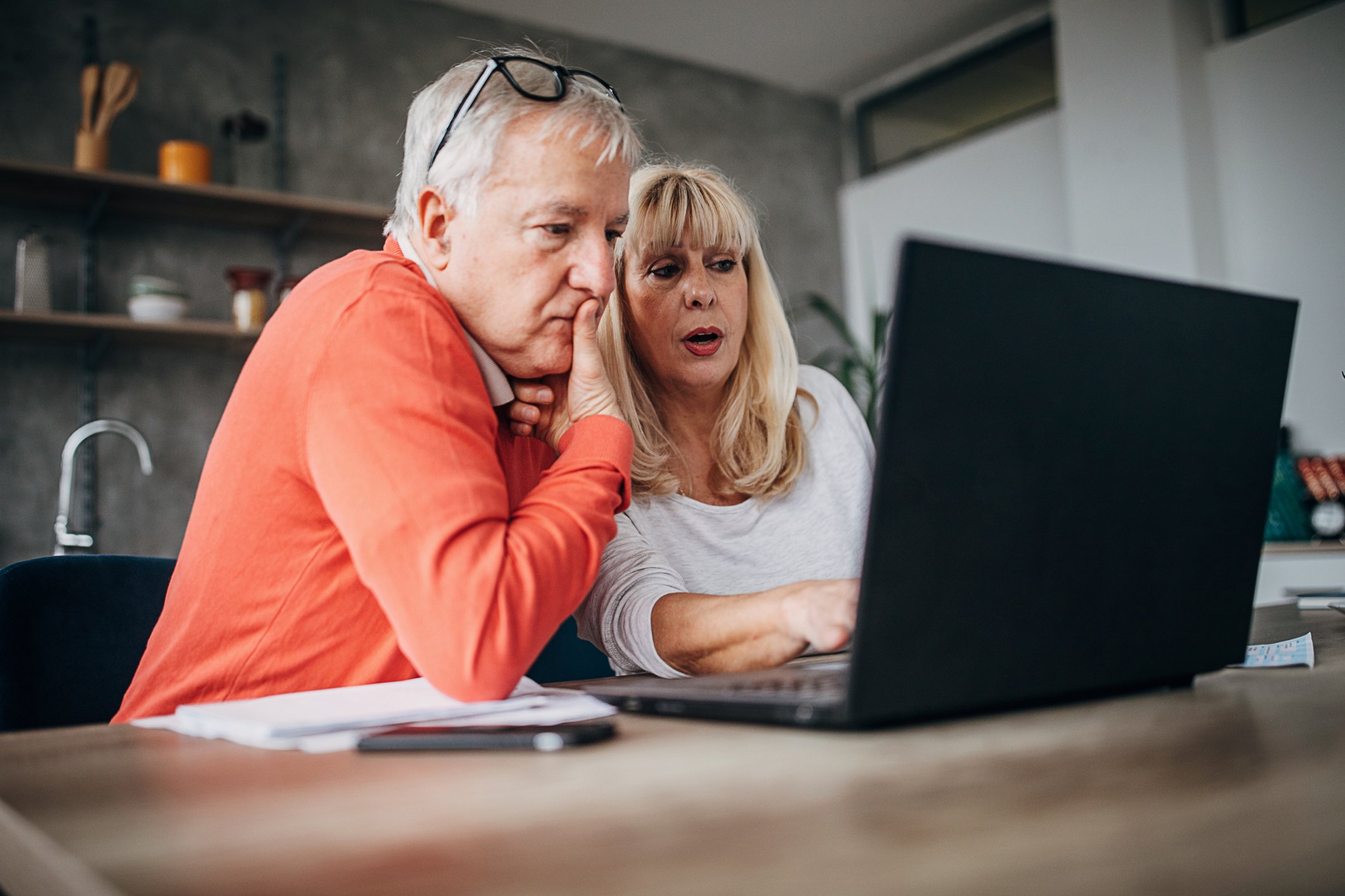 Two seniors at a laptop.