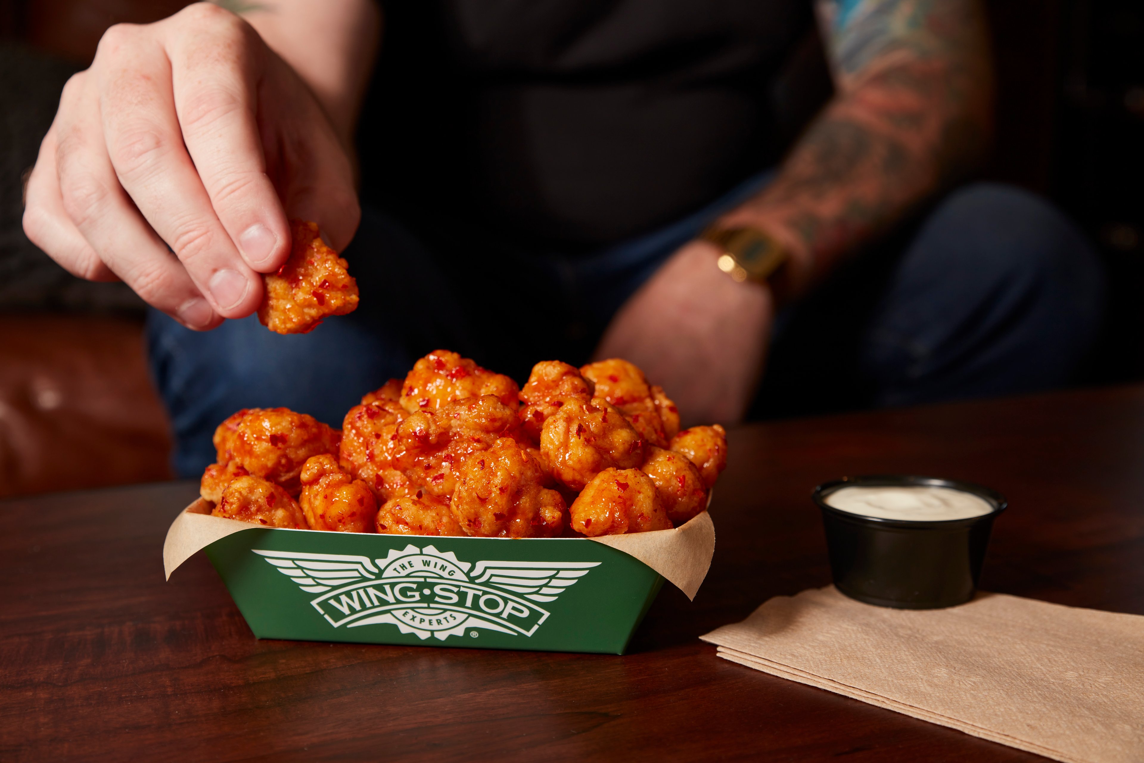 A man eats Wingstop's new chicken thighs.