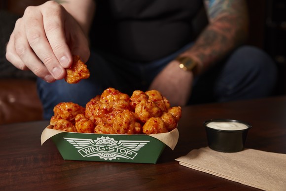 A man eats Wingstop's new chicken thighs.