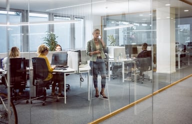 People sitting and standing in an office.