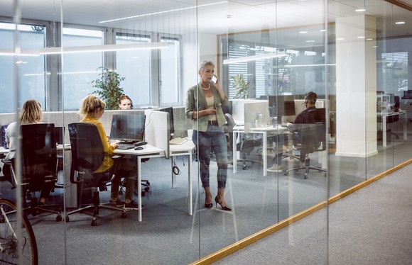 People sitting and standing in an office.