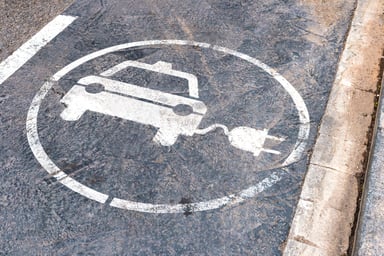 A vehicle charging symbol on the street.