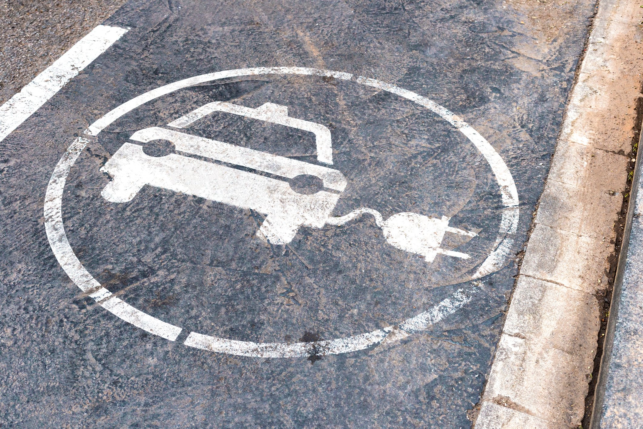 A vehicle charging symbol on the street.