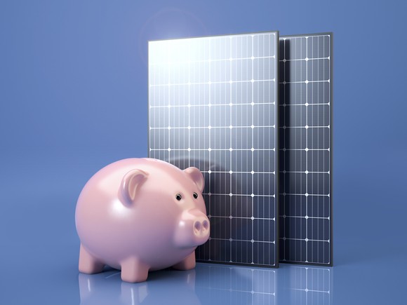 A solar panel and a piggy bank.