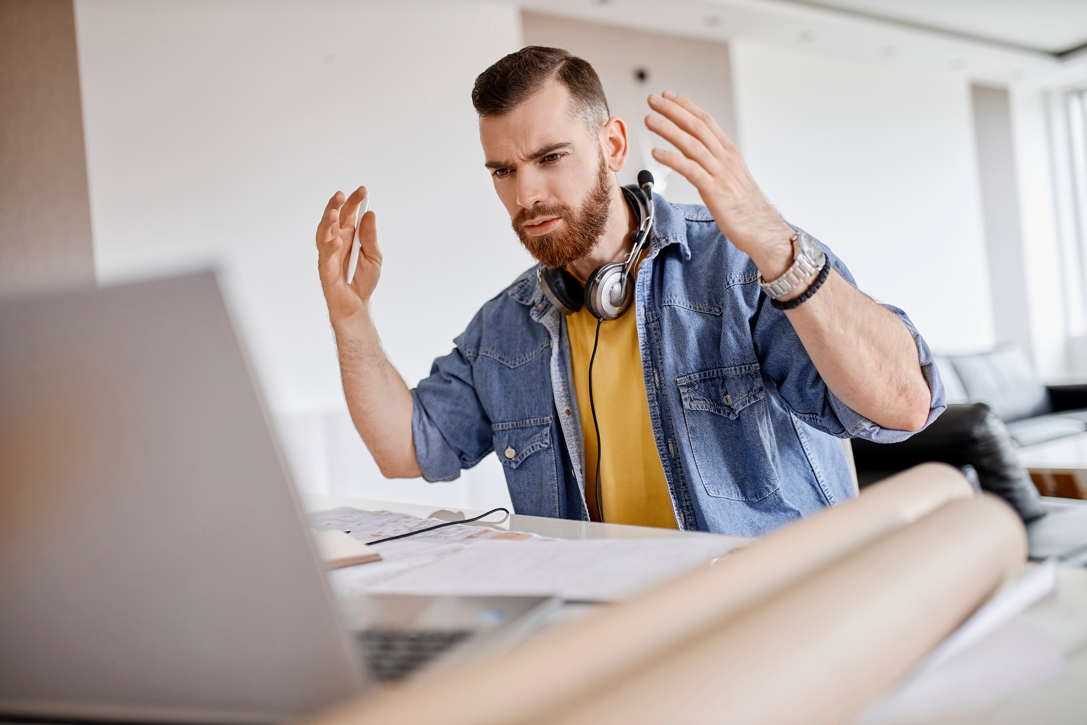 Young man at home is upset at something on his laptop. 