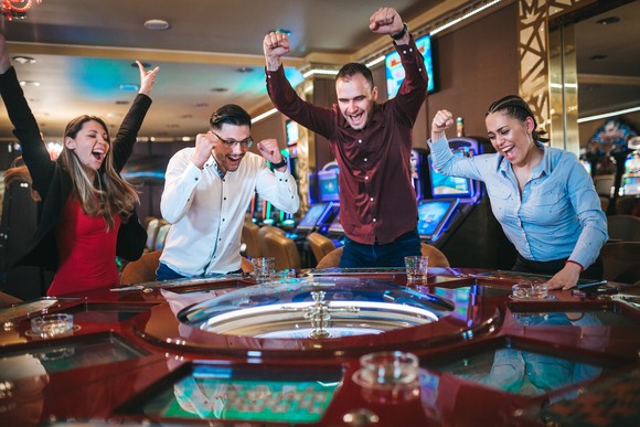 Players celebrating around a roulette wheel.