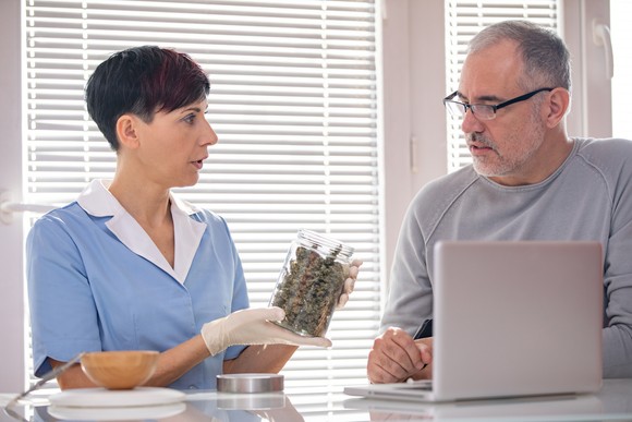 Person showing cannabis products to a patient.