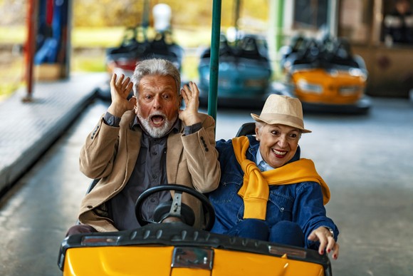 A senior couple enjoying a bumper car ride.