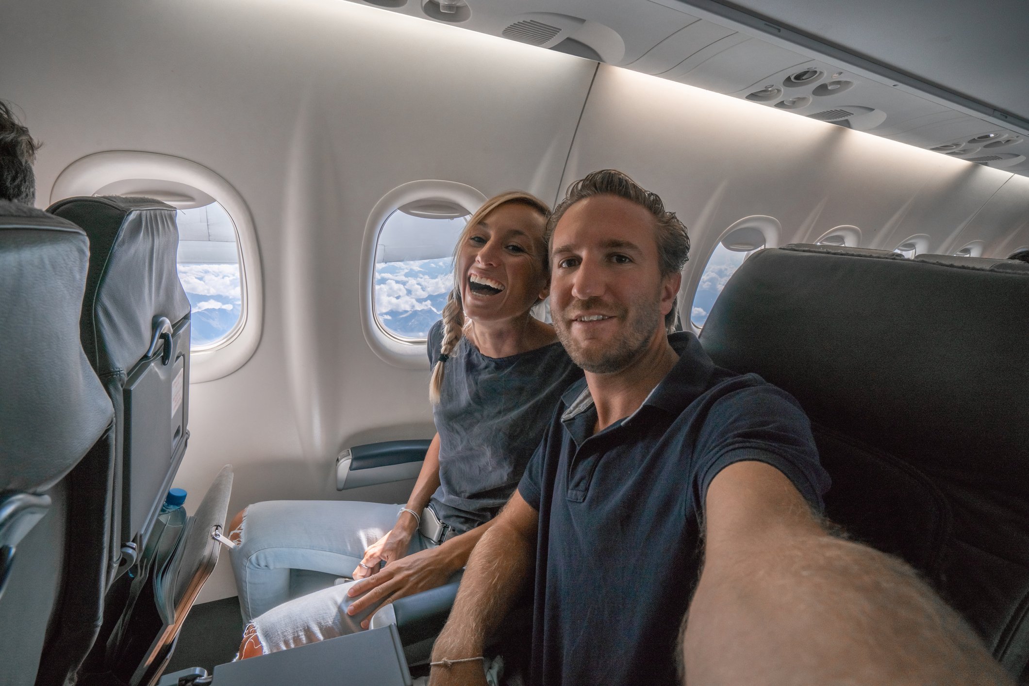 Two people sitting side by side in an airplane cabin.