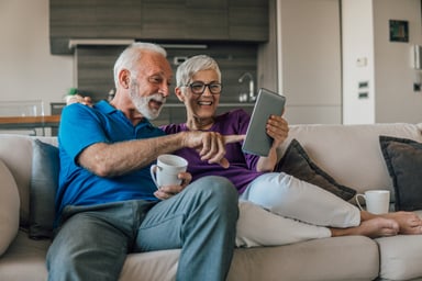 Older couple using tablet computer on a couch