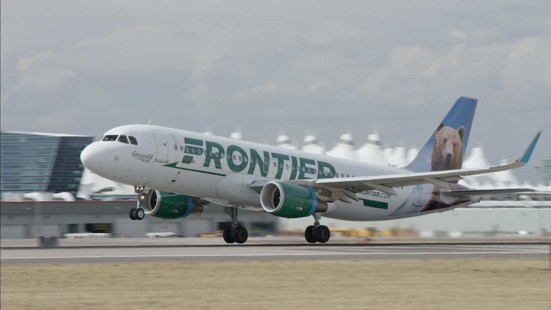 A Frontier Airlines plane landing on a runway.