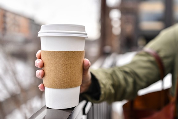 Person holding a coffee cup in right hand.