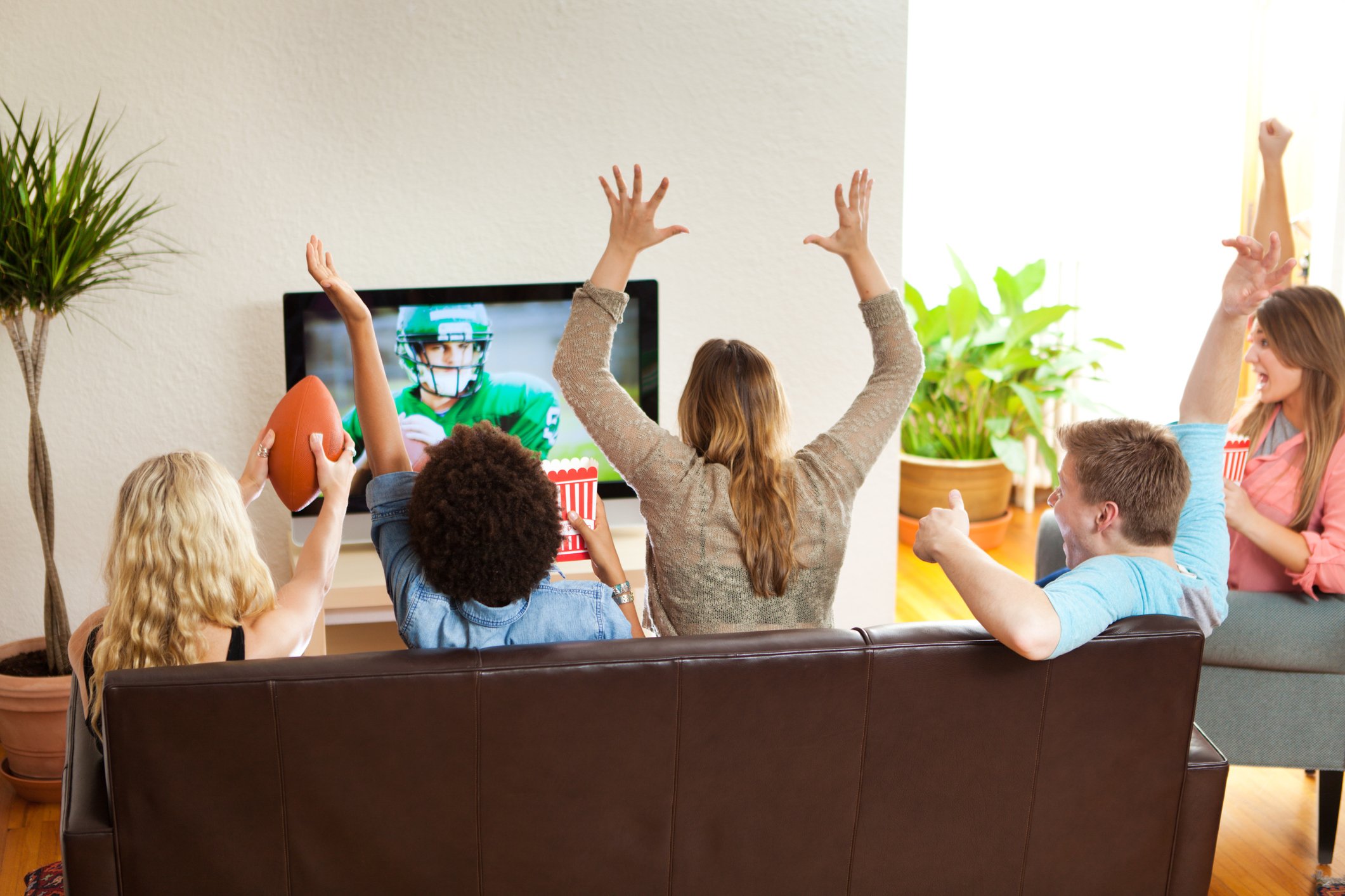 A group of people watching a football game on television.