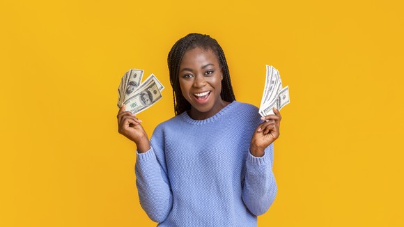 Person smiling while holding cash in both hands.