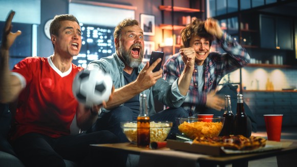 Group of sports fans watching an event on TV.