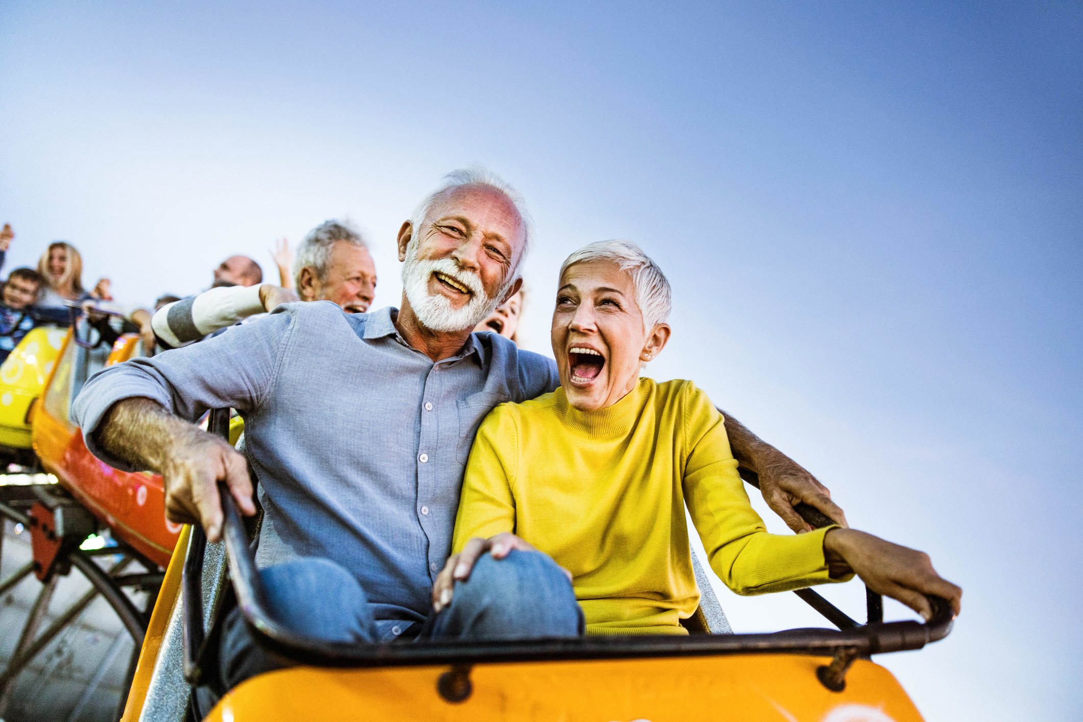 Two people in the front car of a roller coaster.