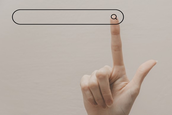 Finger points up to a search bar. 