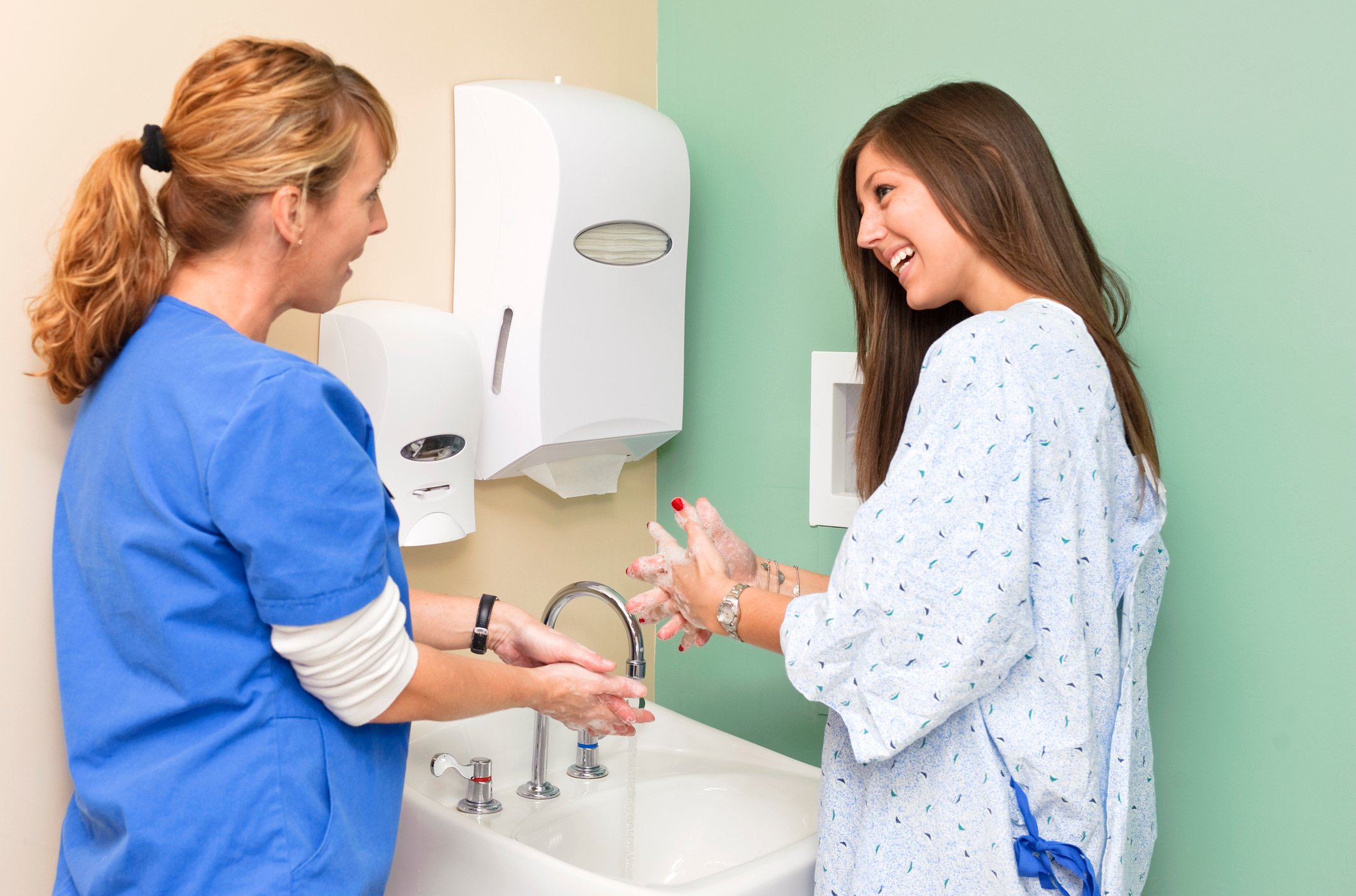 nurse and patient wash hands at sink