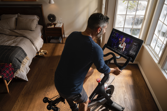 A Peloton member using a bike at home.