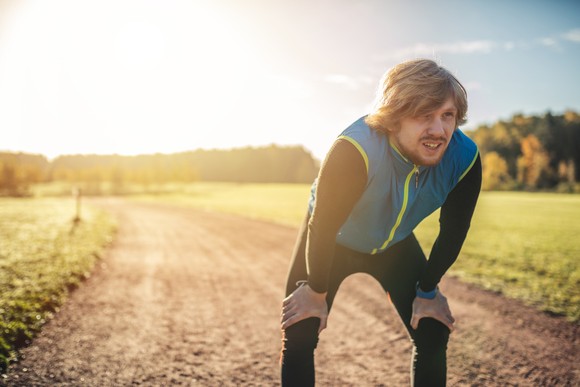 A man takes a break while jogging.