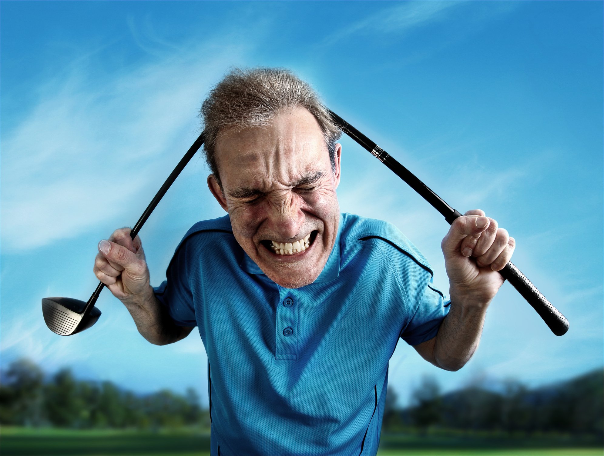 Angry golfer bends a golf club over his head.