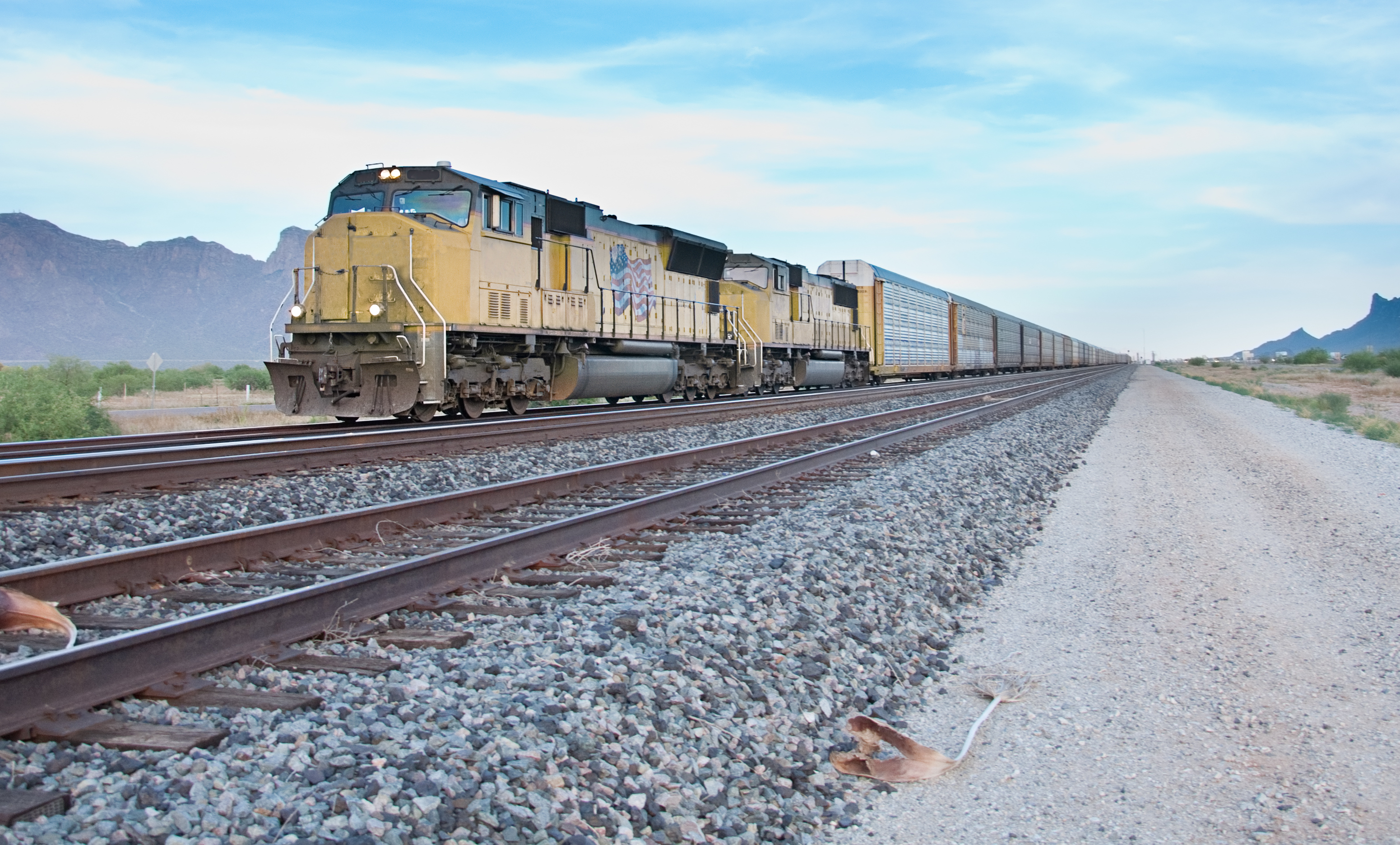 A Union Pacific diesel locomotive moves down a track pulling several cars.