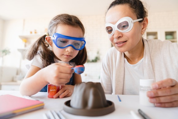 Adult and child using baking soda in an experiment.