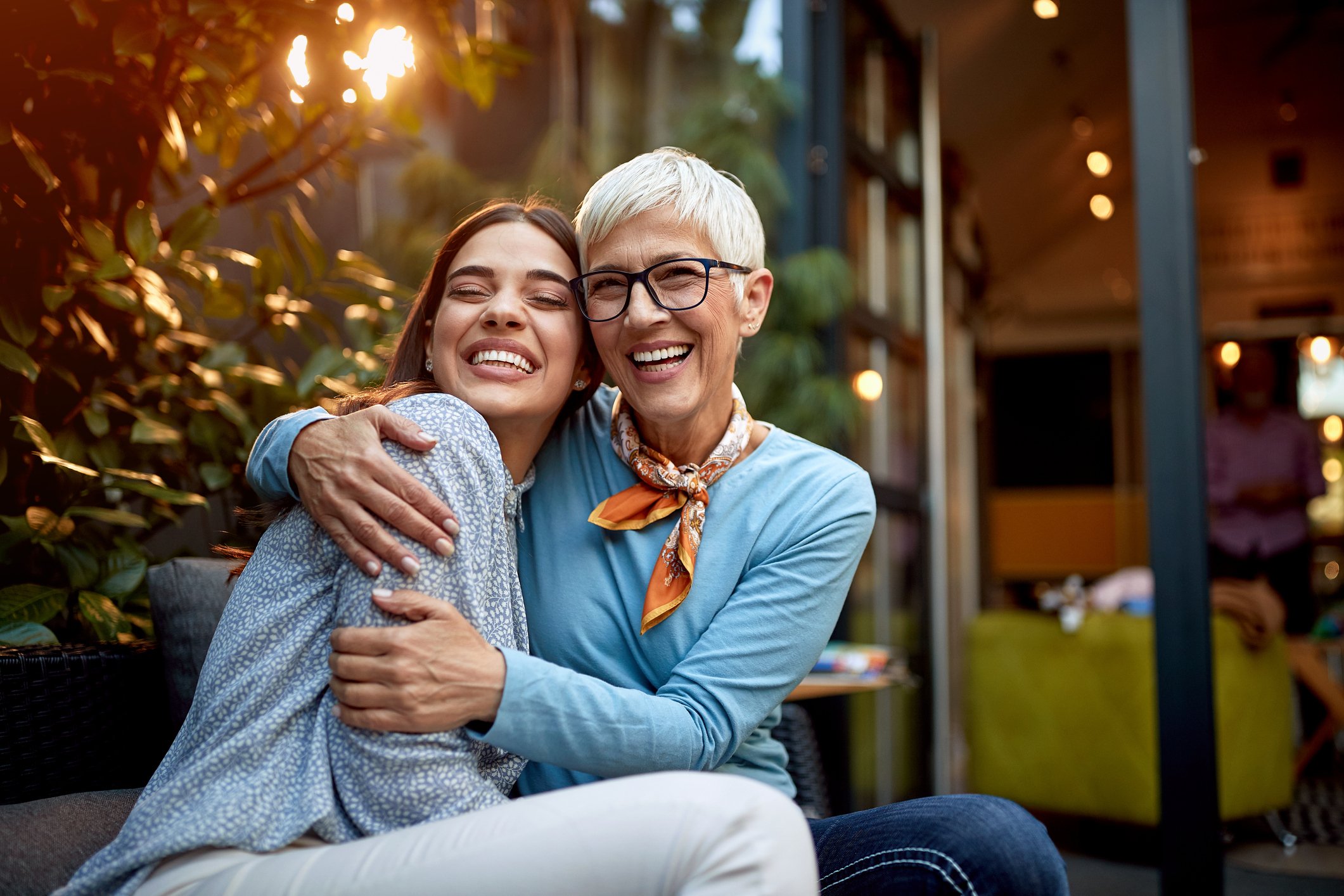 Senior mother and adult daughter hugging.