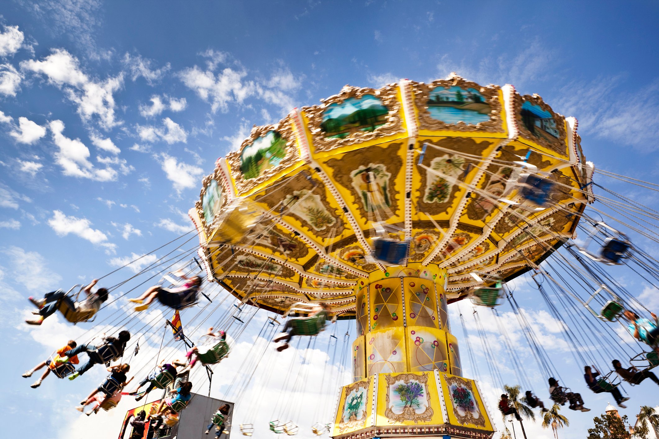 People on a ride are suspended in the air as they are spun around.  


