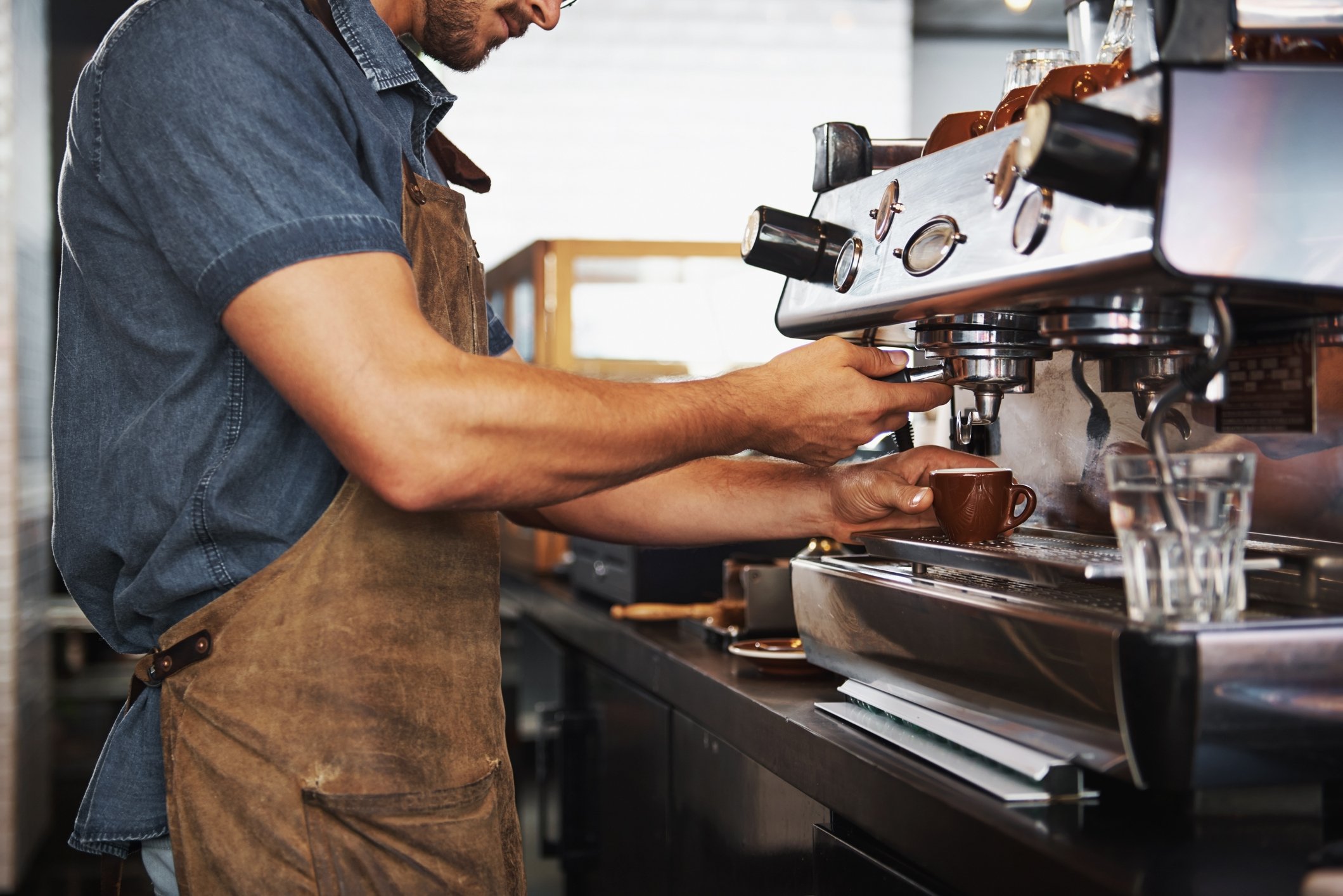 barista making a coffee at espresso machine