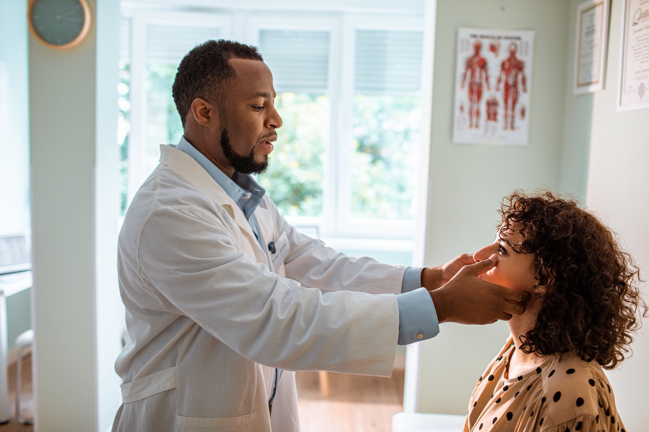 A doctor looks at a patient's face