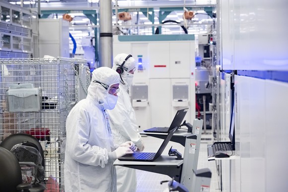 Employees in clean room "bunny suits" working at Intel's D1X factory in Hillsboro, Oregon. A D1X fab expansion due for completion in 2022 will help meet a sharply increasing global demand for semiconductors.