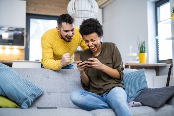 Two people playing a mobile video game.