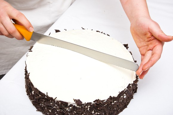 Hands splitting a cake.
