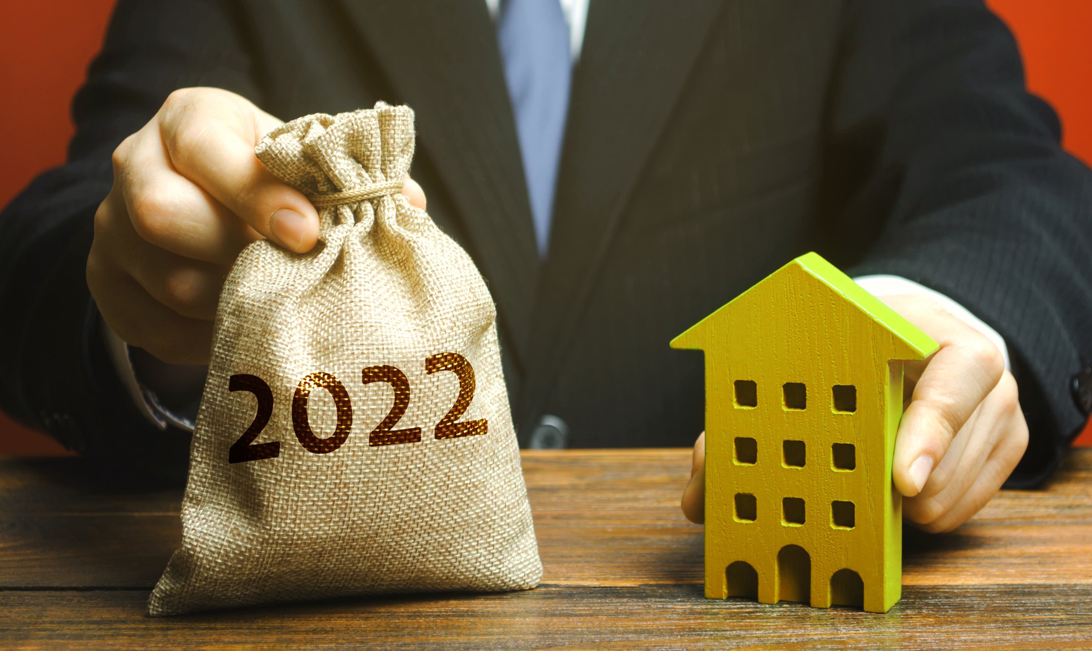 Person holding bag with 2022 on it and a yellow block shaped like an apartment.