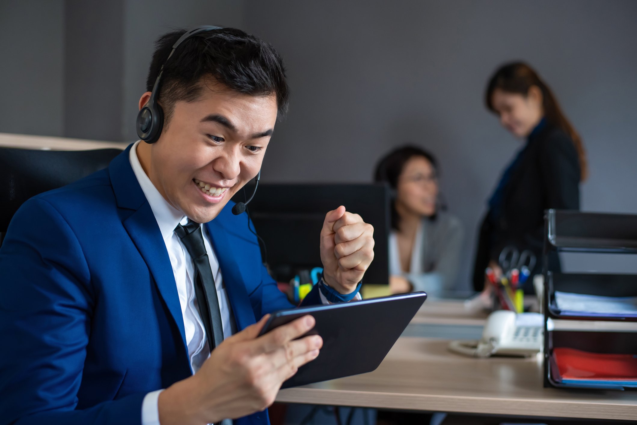 Person excitedly looking at a tablet.