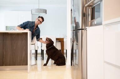 Homeowner in kitchen with dog
