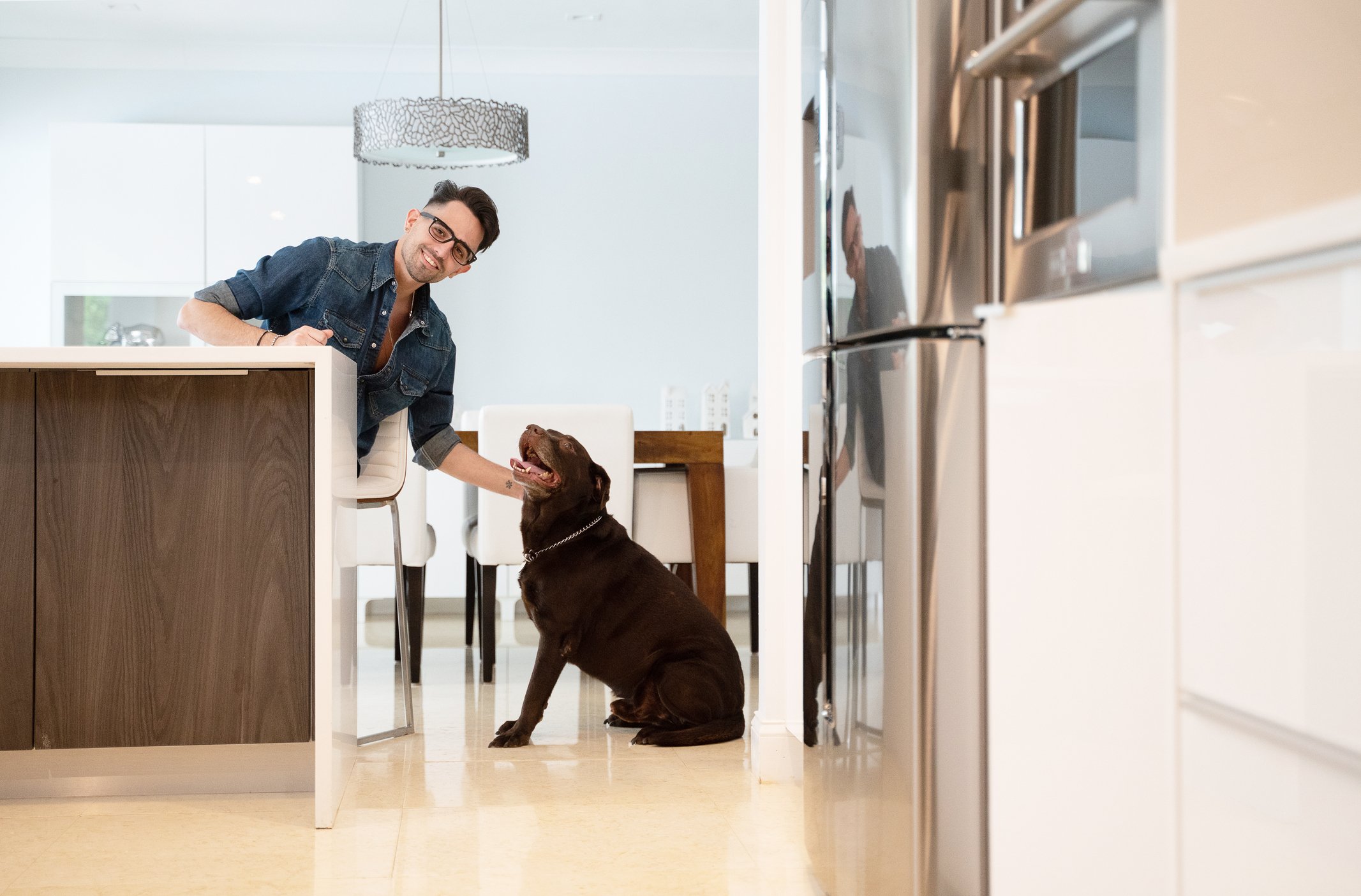 Homeowner in kitchen with dog.